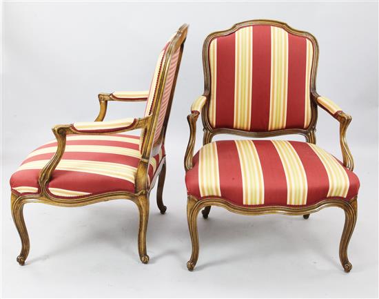 A pair of French carved walnut fauteuils upholstered in striped red and yellow fabric, H. 3ft 2in.